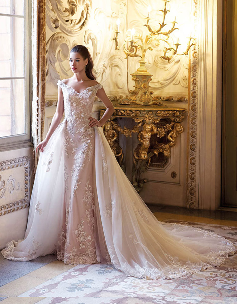 Blush lace wedding gown with a sheer overskirt in an ornate interior