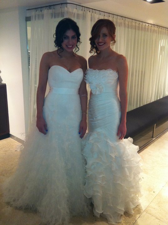 Two brides smiling in wedding gowns inside the Orland Park salon